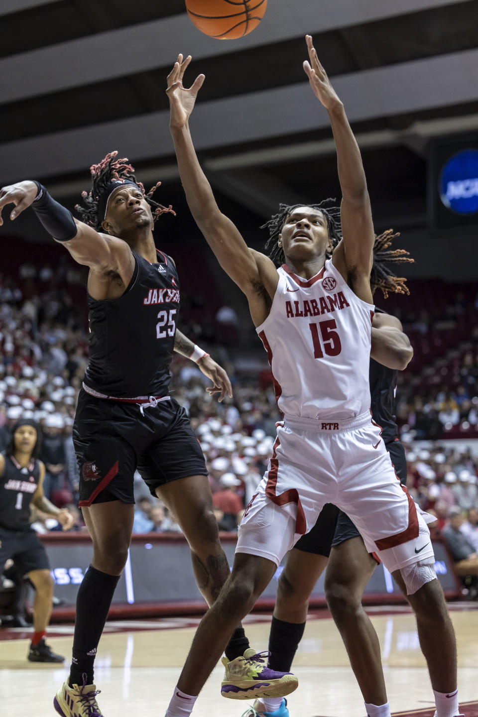 Jacksonville State forward Clarence "Monzy" Jackson (25) and Alabama forward Noah Clowney (15) chase a rebound during the first half of an NCAA college basketball game, Friday, Nov. 18, 2022, in Tuscaloosa, Ala. (AP Photo/Vasha Hunt)