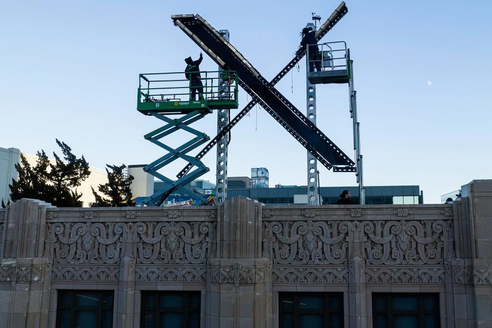 Workers install lighting on an "X" sign atop the downtown San Francisco building that housed what was formally known as Twitter, now rebranded X by owner Elon Musk, Friday, July 28, 2023.