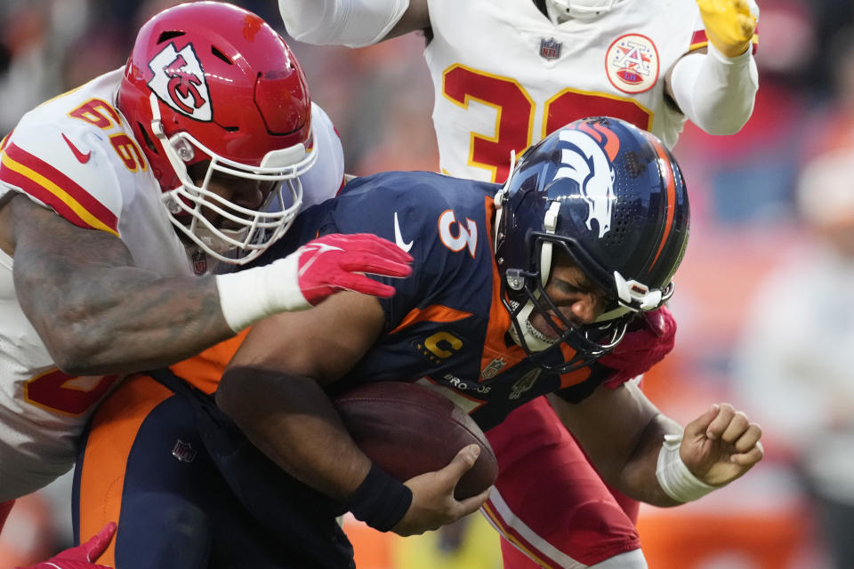 Denver Broncos quarterback Russell Wilson, right, is sacked by Kansas City Chiefs defensive tackle Brandon Williams during the second half of an NFL football game Sunday, Dec. 11, 2022, in Denver. (AP Photo/David Zalubowski)
