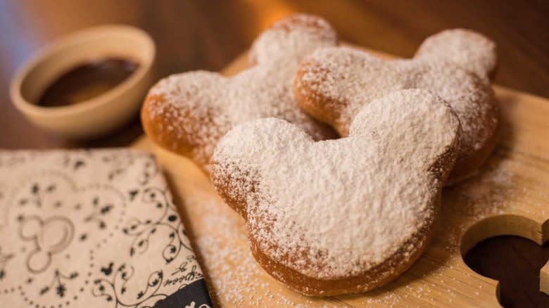 Mickey Mouse-shaped beignets on a cutting board