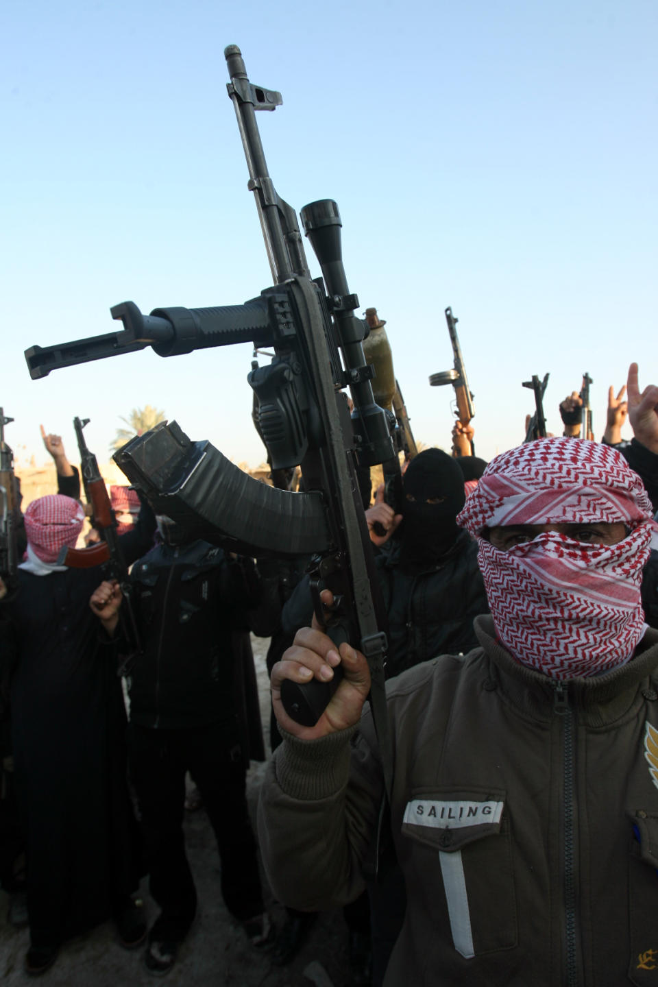 Gunmen gather in a street as they chant slogans against Iraq's Shiite-led government and demanding that the Iraqi army not try to enter the city in Fallujah, 40 miles (65 kilometers) west of Baghdad, Iraq, Tuesday, Jan. 7, 2014. Fierce clashes erupted Tuesday between Iraqi special forces and al-Qaida-linked militants outside the city of Fallujah, a flare-up in a days-long standoff in the Sunni-dominated western province of Anbar, Iraqi officials said. (AP Photo)