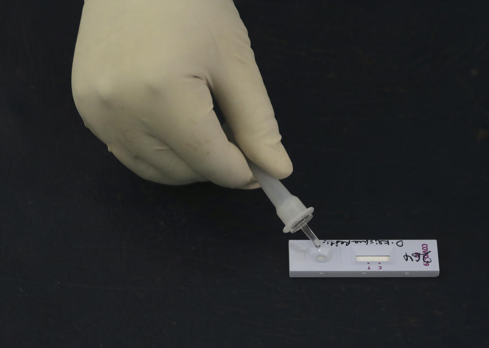 A medical officer uses a rapid kit to test for the coronavirus at a government health center in Hyderabad, India, Wednesday, July 15, 2020. As India’s coronavirus caseload approaches 1 million, lockdowns are being reimposed in parts of the country as governments try to shield the health system from being overwhelmed. (AP Photo/Mahesh Kumar A.)