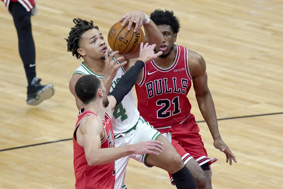 Chicago Bulls' Zach LaVine, left, strips the ball from Boston Celtics' Carsen Edwards (4) as Bulls' Thaddeus Young watches during the first half of an NBA basketball game Monday, Jan. 25, 2021, in Chicago. (AP Photo/Charles Rex Arbogast)