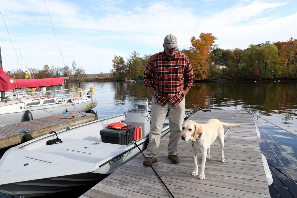 John Lipscomb, boat captain and vice president of advocacy for Riverkeeper, and his dog Batu, after a boat ride on the Hudson River in the Kingston area Oct. 25, 2023, which would be affected by the Coast Guard's decision to redefine the restricted "Port of New York" region for the placement of anchorages for barges in the Hudson. This plan was fought and legislated against earlier.