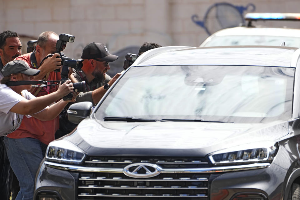 Photojournalists cover the arrival of the vehicle carrying Brazil's former President Jair Bolsonaro at Federal Police headquarters where he will testify in Brasilia, Brazil, Thursday, Aug. 31, 2023. Bolsonaro and seven others were summoned to answer questions about the sale of luxury goods reportedly worth millions, that the former leader received as gifts from Saudi Arabia while in office, according to a Brasilia federal police officer who spoke on condition of anonymity to discuss the ongoing investigation. (AP Photo/Eraldo Peres)