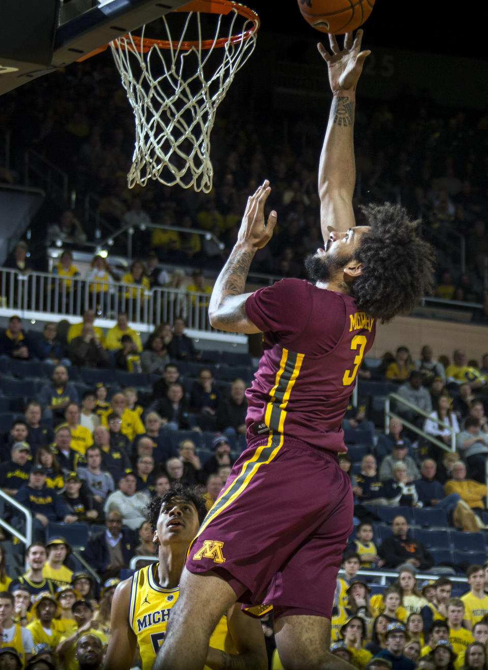 Minnesota forward Jordan Murphy (3) makes a basket, watched by Michigan guard Zavier Simpson, bottom, in the first half of an NCAA college basketball game at Crisler Center in Ann Arbor, Mich., Tuesday, Jan. 22, 2019. (AP Photo/Tony Ding)