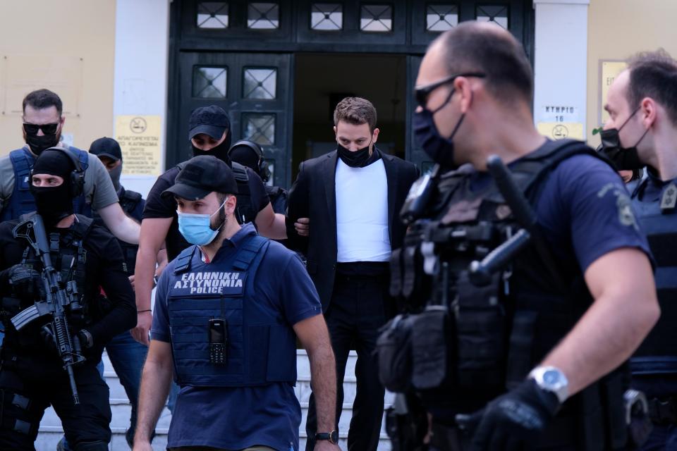 Babis Anagnostopoulos, escorted by police, leaves the court in Athens (AP)