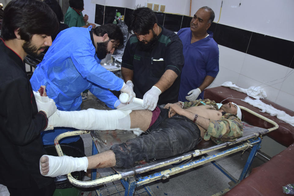 Medical staff provide treatment to a police officer injured in the grenade attack at a hospital in Quetta, Pakistan, Monday, April 8, 2024. A police officer died and six other officers were wounded in a grenade attack Monday at a mosque in southwestern Pakistan, authorities said. (AP Photo/Arshad Butt)