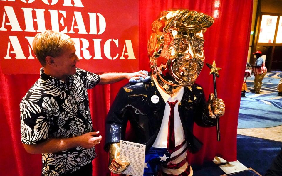 A gold-plated statue of Donald Trump was unveiled at the conference - AP