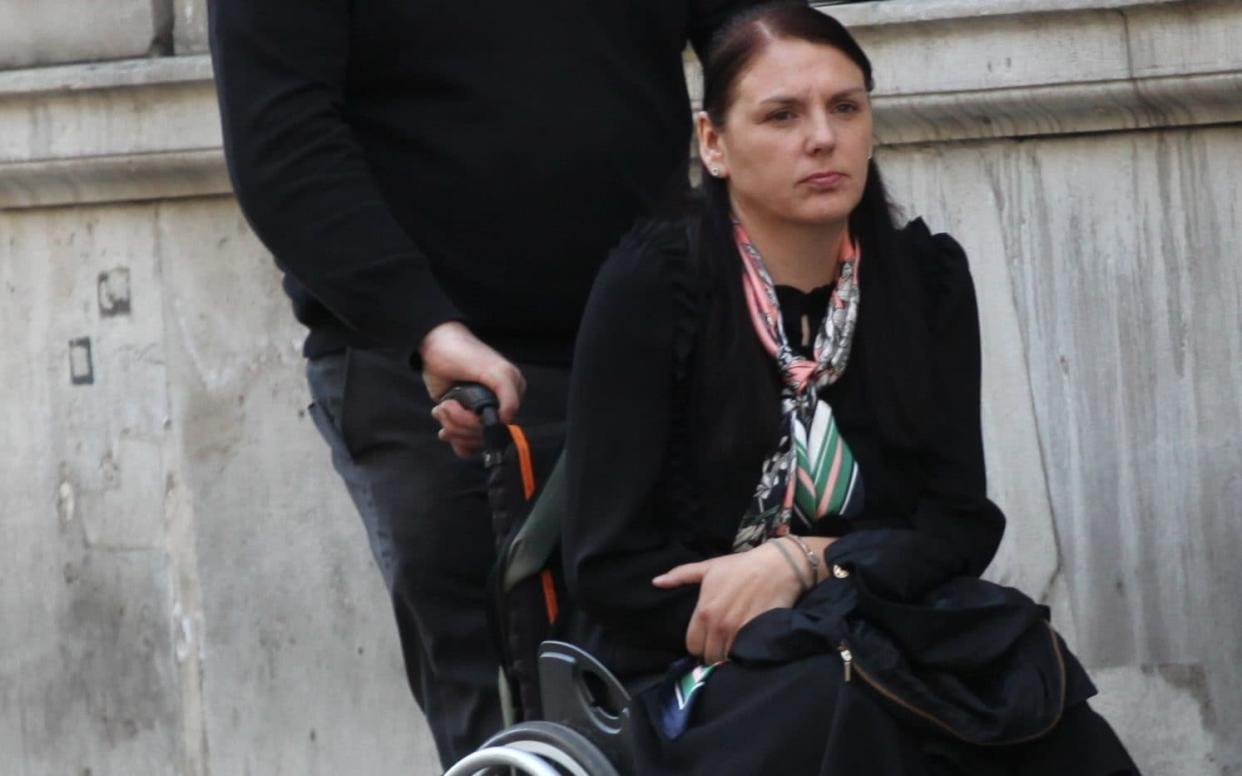 Kerry Shaw, pictured being pushed by her husband Paul, outside High Court during hearing in her fight for damages over back injury - Champion News Service Ltd