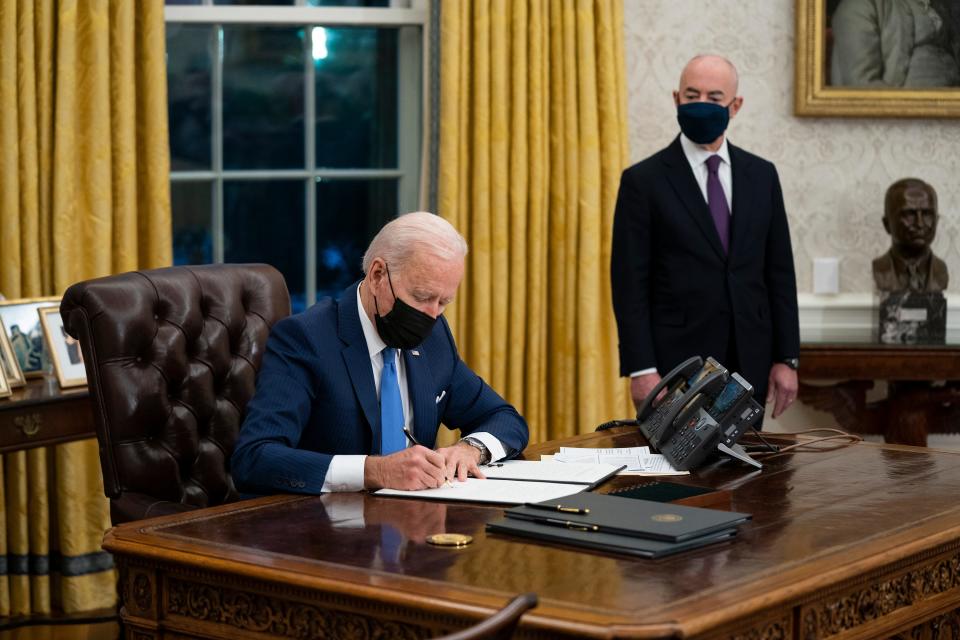 Secretary of Homeland Security Alejandro Mayorkas looks on as President Joe Biden signs an executive order on immigration, in the Oval Office of the White House, Feb. 2, 2021, in Washington. 