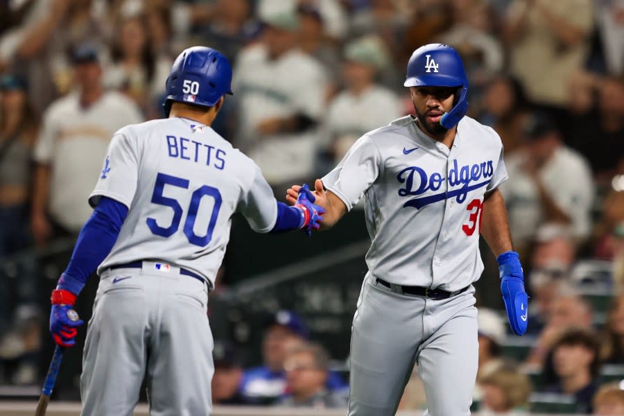 Los Angeles Dodgers' Amed Rosario, right, celebrates with Mookie Betts after scoring off a sacrifice fly hit by Kolten Wong against the Seattle Mariners during the 10th inning of a baseball game Saturday, Sept. 16, 2023, in Seattle. (AP Photo/Maddy Grassy)