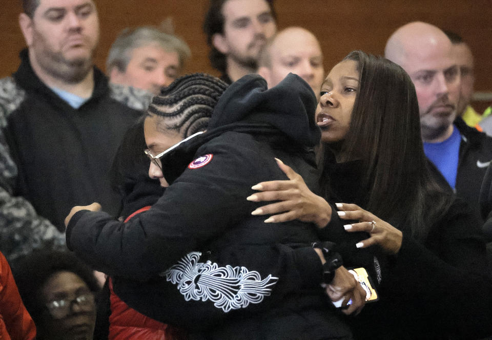 Family members of the victims embrace before the arraignment Thursday, Dec. 7, 2023 in Waltham, Mass. Peter Simon was arraigned in Waltham District Court on a litany of charges including manslaughter in the traffic deaths of police officer Paul Tracey and a National Grid worker. (Lane Turner/The Boston Globe via AP, Pool)