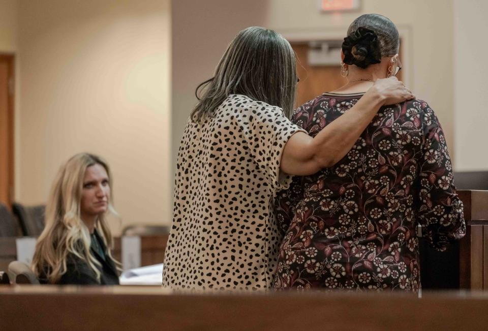 L-R Monmouth county assistant prosecutor Caitlin Sidley looks on as Donna Walcott helps her sister Vicki Scott read her impact statement to the court in the killing of Scott's son Denzel Morgan-Hicks.