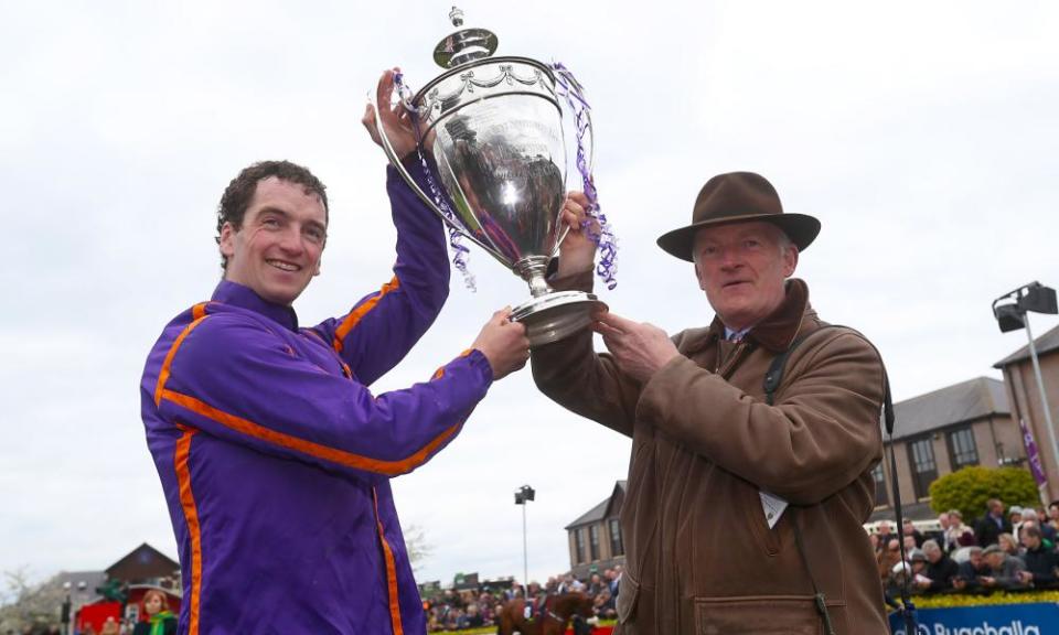 Trainer Willie Mullins, right, and son jockey Patrick lift the cup in the parade ring after winning the Punchestown Champion Hurdle with Wicklow Brave on Friday.