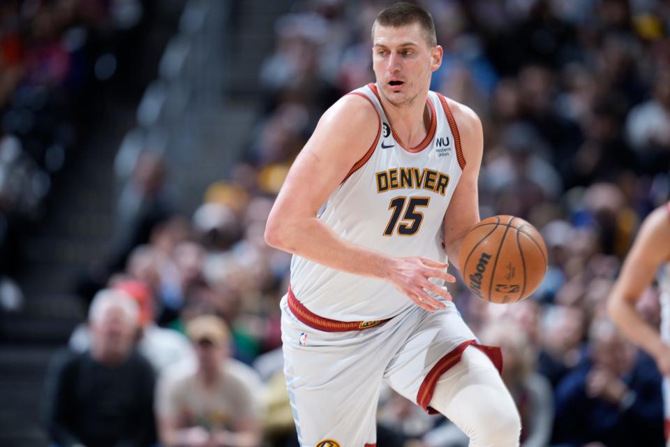 Denver Nuggets center Nikola Jokic picks up a loose ball in the first half of an NBA basketball game against the Phoenix Suns Wednesday, Jan. 11, 2023, in Denver. (AP Photo/David Zalubowski)
