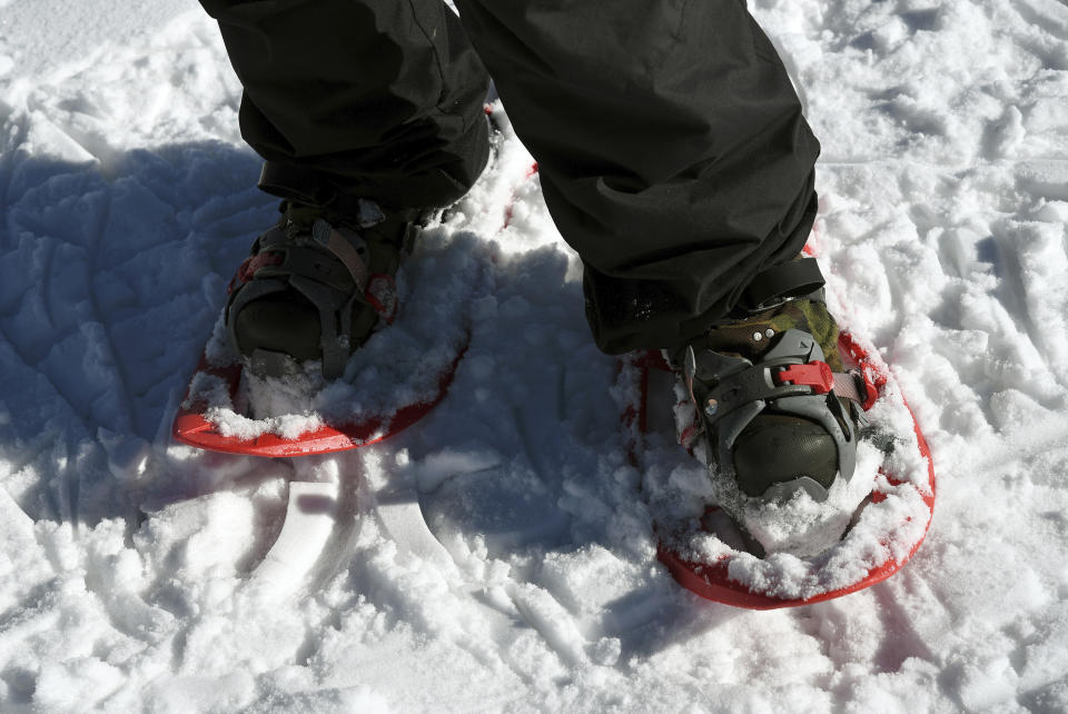 In this photo taken Jan. 7, 2020, British artist Simon Beck uses snowshoes to create a massive geometrical design on a reservoir near Silverthorne, Colo. His drawings are commissioned around the world, he has published a book and has attracted a dedicated fan base. (AP Photo/Thomas Peipert)