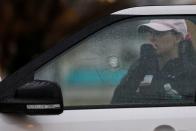 A woman stands behind a car with shattered glass near the scene of a shooting at the Boise Towne Square shopping mall in Boise, Idaho