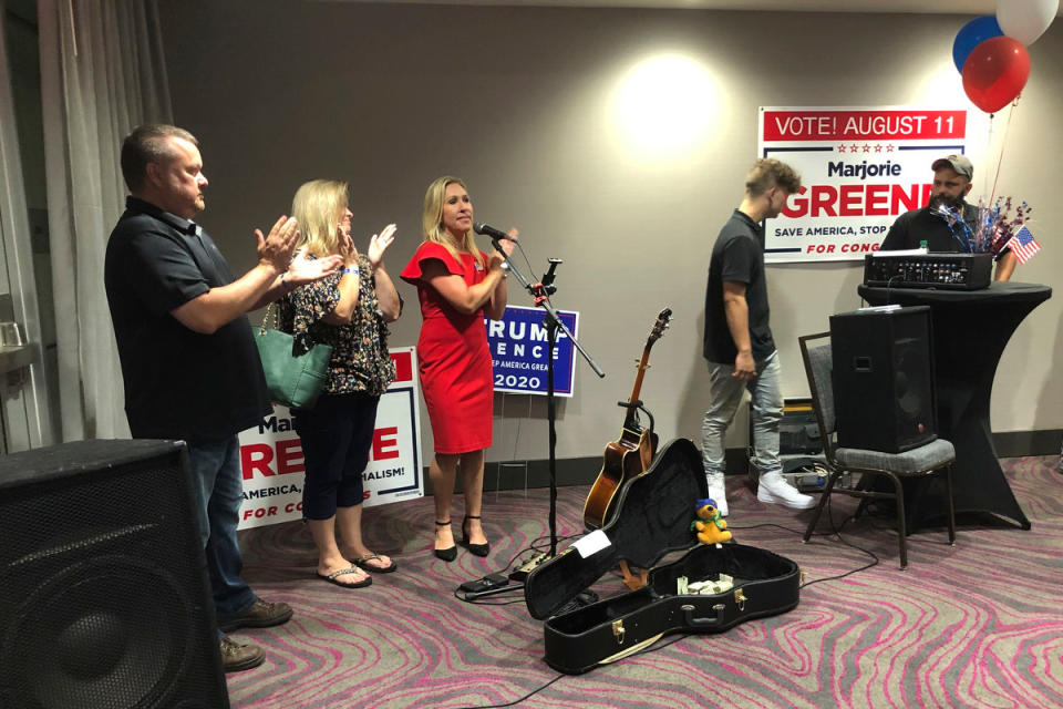 Construction executive Marjorie Taylor Greene, third from left, claps with her supporters at a watch party event, late Tuesday, Aug. 11, 2020, in Rome, Ga.