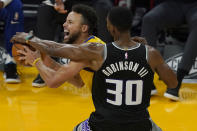 Golden State Warriors guard Stephen Curry, left, is defended by Sacramento Kings forward Glenn Robinson III during the first half of an NBA basketball game in San Francisco, Monday, Jan. 4, 2021. (AP Photo/Jeff Chiu)