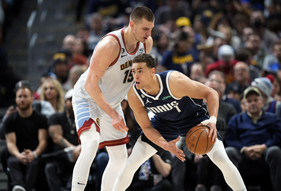 Dallas Mavericks center Dwight Powell, right, looks to pass the ball as Denver Nuggets center Nikola Jokic defends in the second half of an NBA basketball game Wednesday, Feb. 15, 2023, in Denver. (AP Photo/David Zalubowski)