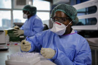 In this photo taken Sunday, April 5, 2020, laboratory technicians work on testing patient samples for the new coronavirus that causes COVID-19, at the Pathologists Lancet Kenya laboratory in Nairobi, Kenya. The company, which is offering tests to patients with a doctor's referral, was previously having to send samples to South Africa for testing but is now completing the testing in-house in Kenya. (AP Photo/Brian Inganga)