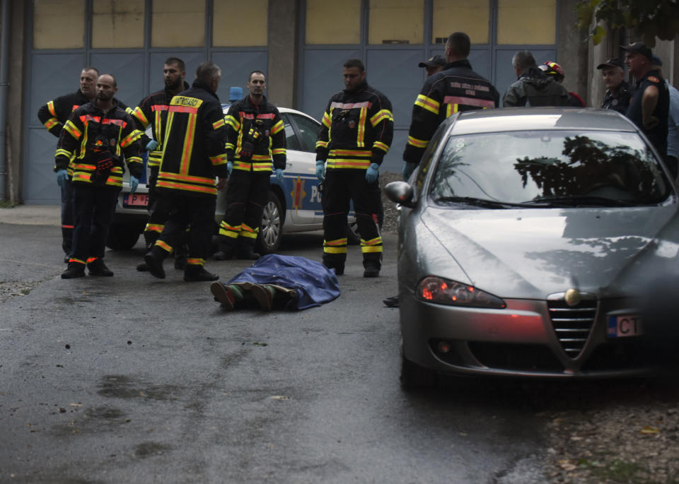 REMOVES SPECIFIC NUMBER OF CASUALTIES AND CLARIFIES SHOOTING DETAILS Firefighters stand by a body on the site of the attack in Cetinje, some 30 km west of Podgorica, Montenegro, Friday, Aug. 12, 2022. A man went on a shooting rampage in the streets of a western Montenegro city Friday, killing multiple people, before being shot dead by a passerby, officials said. (AP Photo/Risto Bozovic)