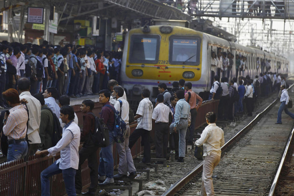 Commuters wait to board a train in Mumbai, India.