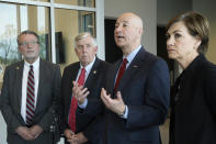 FILE- In this April 26, 2019 file photo, Iowa Gov. Kim Reynolds, right, Nebraska Gov. Pete Ricketts, second right, Missouri Gov. Mike Parson, and Kansas Lt. Gov. Lynn Rogers, left, answer questions following a meeting in Council Bluffs, Iowa. Nebraska, Iowa, Kansas and Missouri are joining forces for a study that will look for ways the states can limit flooding along the Missouri River and give them information about how wetter weather patterns could require changes to the federal government's management of the basin's reservoirs. The states are pooling their money to pay for half of a $400,000 study with the U.S. Army Corps of Engineers to measure how much water flows down the Missouri River. (AP Photo/Nati Harnik)