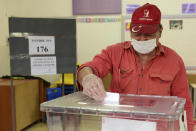 A man casts his ballot at a polling station during Turkish Cypriots election for a new leader in the Turkish occupied area in the north part of the divided capital Nicosia, Cyprus, Sunday, Oct. 18, 2020. Turkish Cypriots vote to choose a leader who'll explore, with rival Greek Cypriots, whether there's enough common ground left for a deal to end the island's decades of ethnic division. (AP Photo/Nedim Enginsoy)