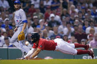 Boston Red Sox's Xander Bogaerts, right, beats the throw to score on an RBI-single by Reese McGuire as Toronto Blue Jays starting pitcher Kevin Gausman, left, backs up the play during the second inning of a baseball game, Thursday, Aug. 25, 2022, in Boston. (AP Photo/Charles Krupa)