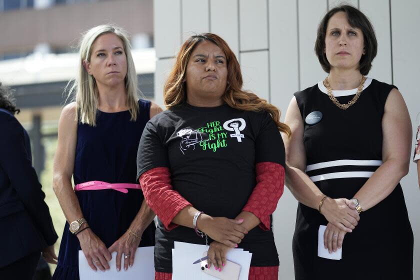 FILE - Amanda Zurawski, who developed sepsis and nearly died after being refused an abortion when her water broke at 18 weeks, left, and Samantha Casiano, who was forced to carry a nonviable pregnancy to term and give birth to a baby who died four hours after birth, center, stand with their attorney Molly Duane outside the Travis County Courthouse, Wednesday, July 19, 2023, in Austin, Texas. A Texas judge ruled Friday, Aug. 4, 2023, the state's abortion ban has proven too restrictive for women with serious pregnancy complications and must allow exceptions without doctors fearing the threat of criminal charges. The challenge is believed to be the first in the U.S. brought by women who have been denied abortions since the Supreme Court last year overturned Roe v. Wade, which for nearly 50 years had affirmed the constitutional right to an abortion. (AP Photo/Eric Gay, File)