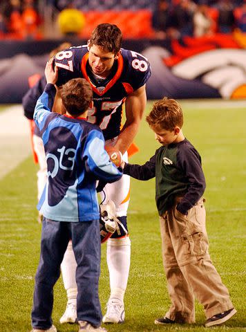 <p>Cyrus McCrimmon/The Denver Post via Getty </p> Ed McCaffrey greets his sons Max McCaffrey (left) and Christian McCaffrey on the field