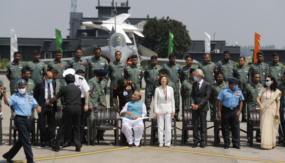 Indian Defense Minister Rajnath Singh, center left and French Defense Minister Florence Parly, center right, pose for a group photo with Rafale squadron during an induction ceremony of French-made Rafale fighter jets at Air Force Station Ambala, India, Thursday, Sept.10, 2020. The first batch of five planes, part of a $8.78 billion deal signed between the two countries in 2016 had arrived here in July. (AP Photo/Manish Swarup)