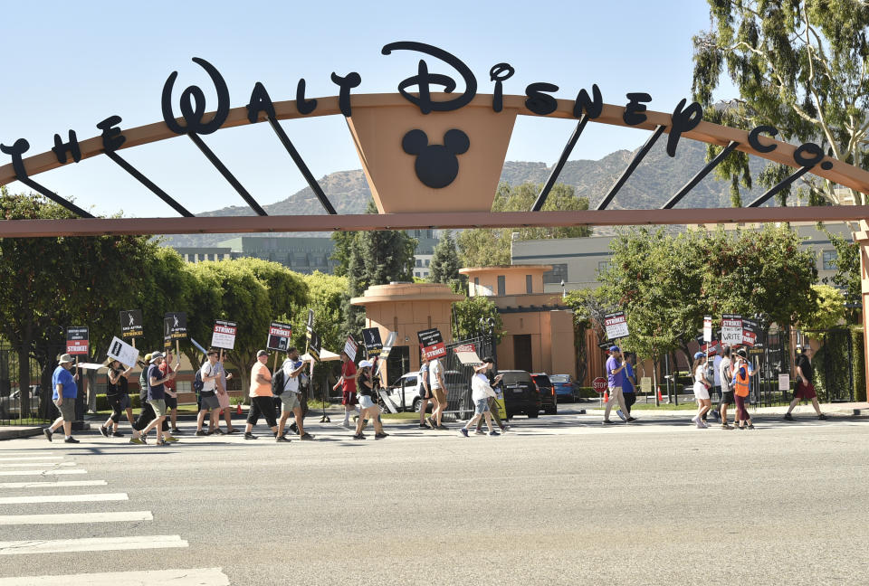 Picketers carry signs outside Disney studios on Thursday, July 20, 2023, in Burbank, Calif. The actors strike comes more than two months after screenwriters began striking in their bid to get better pay and working conditions. (Photo by Richard Shotwell/Invision/AP)