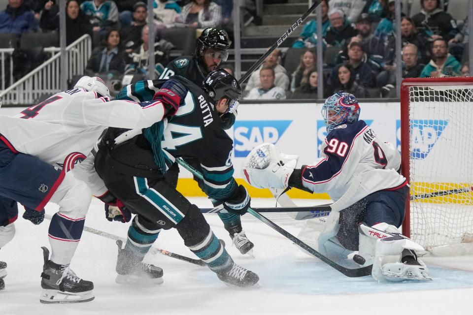 Columbus Blue Jackets goaltender Elvis Merzlikins (90) defends against a shot by San Jose Sharks defenseman Jan Rutta (84) during the first period of an NHL hockey game in San Jose, Calif., Saturday, Feb. 17, 2024. (AP Photo/Jeff Chiu)