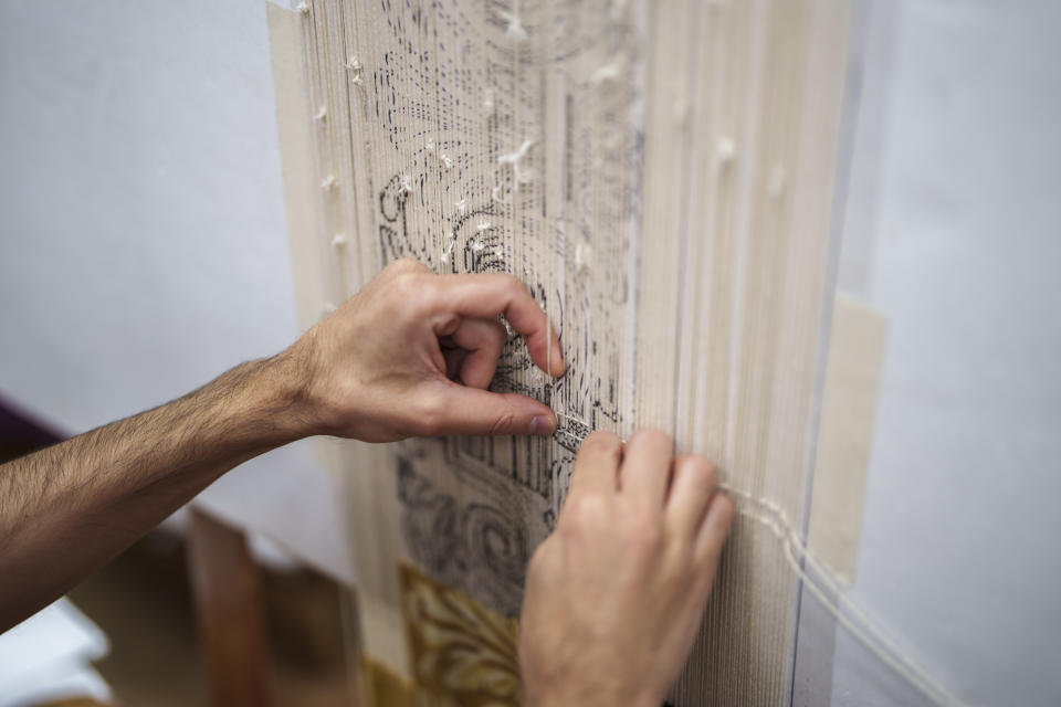 A craftsman works on a tapestry at the Royal Tapestry Factory in Madrid, Spain, Friday, Nov. 30, 2023. Since its foundation in 1721, the Royal Tapestry Factory of Madrid has not stopped producing. It was Philip V, then King of Spain, who had the factory built with the help of Catholic craftsmen from Flanders to replace the lack of private initiative that existed at the time. (AP Photo/Manu Fernandez)