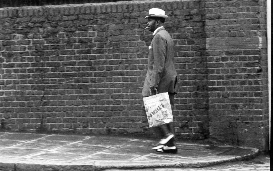 A man fashionably dressed in a zoot suit walking down Great Western Road, Notting Hill, London, 1968. (Photo by Charlie Phillips/Getty Images)  - Getty