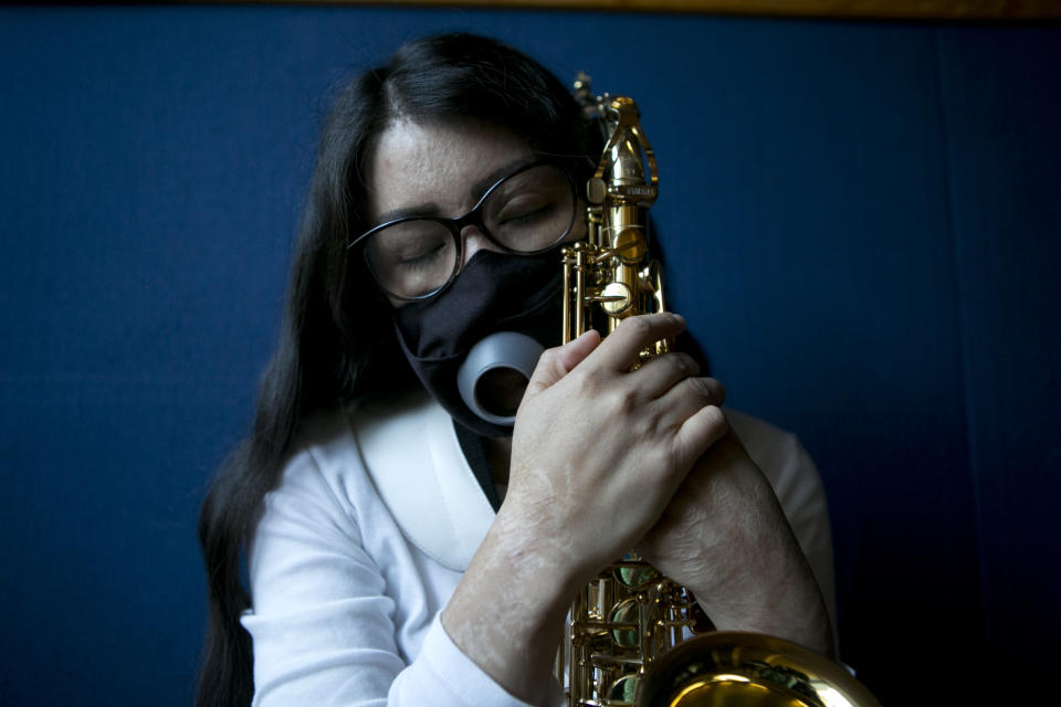 María Elena Ríos sostiene su saxofón al final de un ensayo en la facultad de música de la Universidad Nacional Autónoma de México, en la Ciudad de México, el martes 14 de febrero de 2023. El saxofón significa vida para Ríos, pero llegó a odiarlo porque casi le causa la muerte. Eso es lo que creyó por un tiempo la mexicana de 29 años sobreviviente de un ataque con ácido de su expareja. (Foto AP/Ginnette Riquelme)