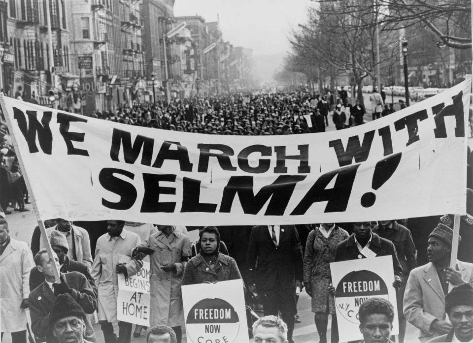 <p>Men carrying a "We march with Selma!" banner lead 15,000 marchers through the streets of Harlem. </p>