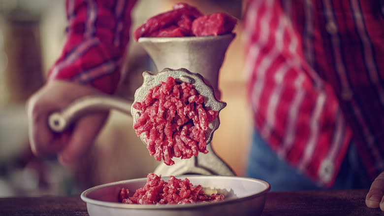 A man grinding meat 