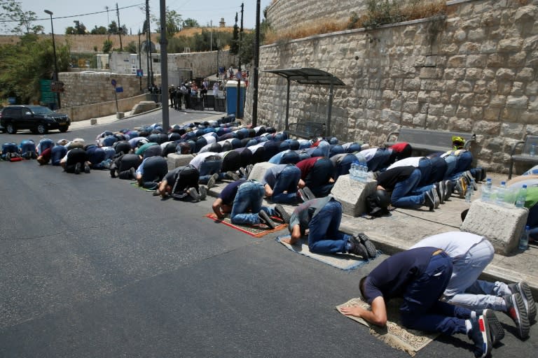 Palestinians pray outside the main entrance to the Al-Aqsa mosque compound in Jerusalem's Old City on July 22, 2017 in protest at Israeli security measures implemented at the holy site