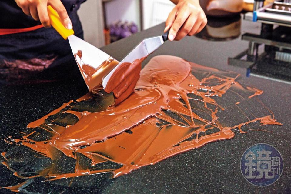 融化的巧克力在大理石板上翻炒降溫，結晶體改變，光澤度增加，口感也更滑順。