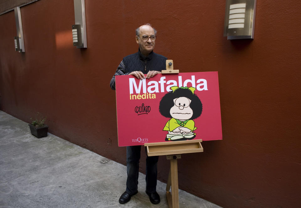 FILE - In this Nov. 26, 2008 file photo, Argentine cartoonist Joaquin Salvador Lavado, better known as "Quino," poses with his character Mafalda during a news conference in Mexico City. Lavado passed away on Wednesday, Sept. 30, 2020, according to his editor Daniel Divinsky who announced it on social media. (AP Photo/Dario Lopez-Mills, File)