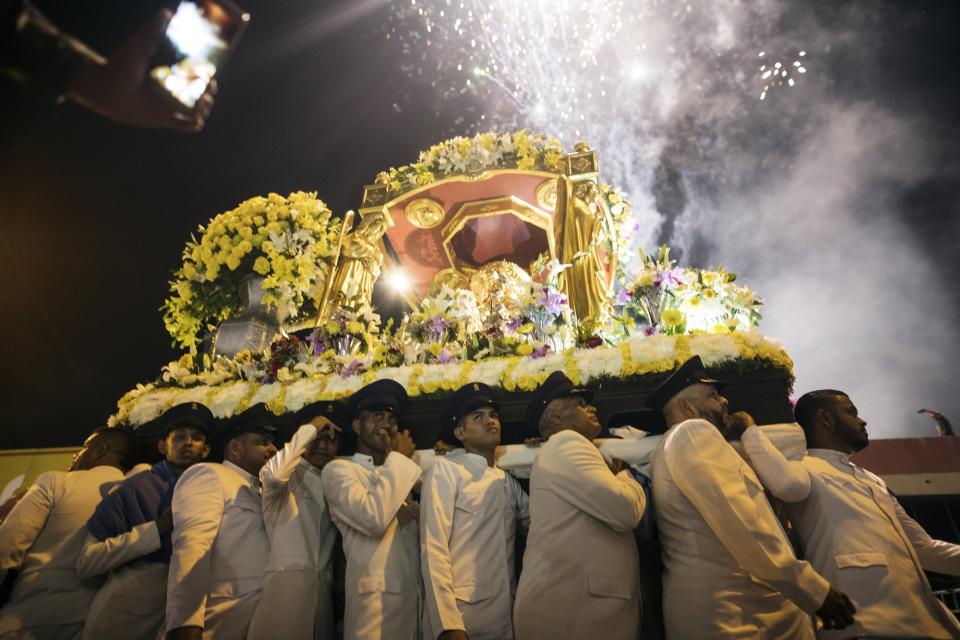 In this Nov. 18, 2019 photo, faithful referred to as "Servidores Mañaneros" or morning servers, carry the image of the Virgin of Chiquinquira during a procession, in Maracaibo, Venezuela. Thousands of Venezuelans flocking to Maracaibo’s ornate basilica each year at this time traditionally ask for help overcoming illness or conceiving a child. But many faithful say a crisis driving the exodus of millions has made them ask for something bigger than themselves. (AP Photo/Rodrigo Abd)