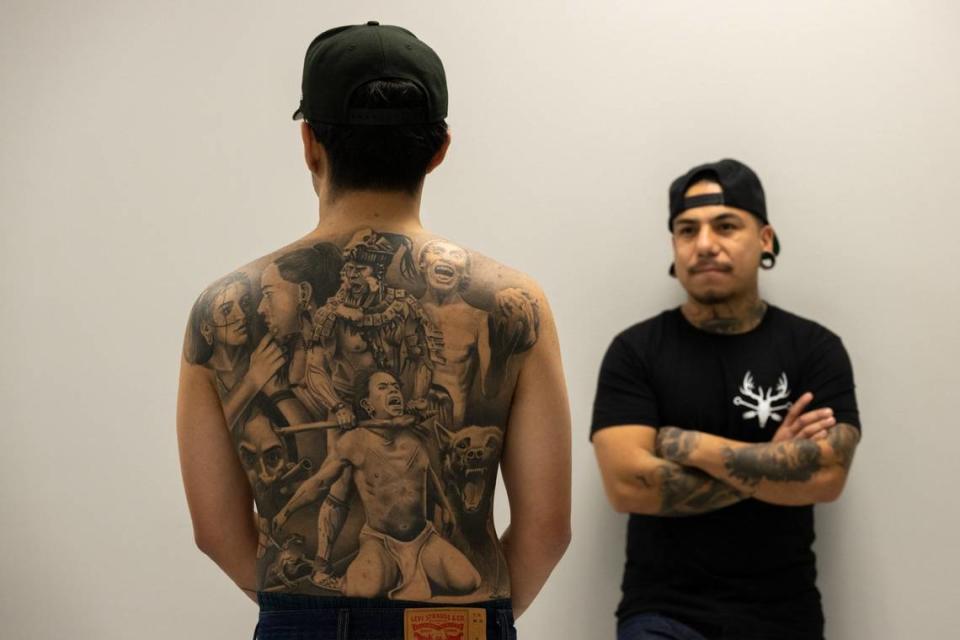 Tattoo artist Cristiano Ochoa, left, displays a creation by tattoo artist Edgar Avila at Elk Grove Tattoo earlier this month.