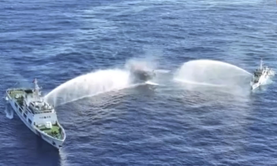 In this image made from video provided by the Philippine Coast Guard, Philippine resupply vessel Unaizah May 4, center, is hit by two Chinese coast guard water canon blasts, causing injuries to multiple crew members as they tried to enter the Second Thomas Shoal, locally known as Ayungin Shoal, in the disputed South China Sea, Tuesday, March 5, 2024. Chinese and Philippine coast guard vessels collided in the disputed South China Sea and multiple Filipino crew members were injured in high-seas confrontations Tuesday as Southeast Asian leaders gathered for a summit that was expected to touch on Beijing's aggression at sea. (Philippine Coast Guard via AP)