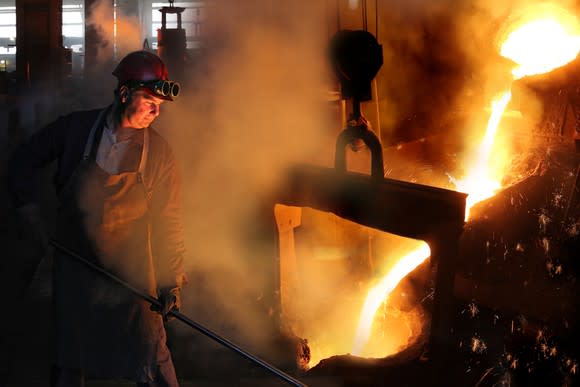 A man pouring molten metal in a steel mill