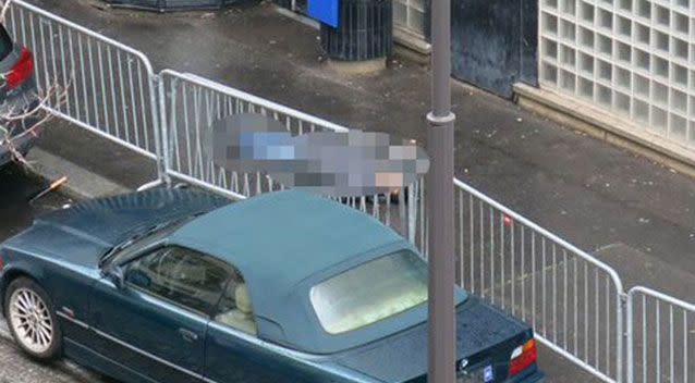 The man's body lay in the street as bomb disposal experts were deployed to see if a vest the man was wearing had explosives. Photo: Anna Polonyi