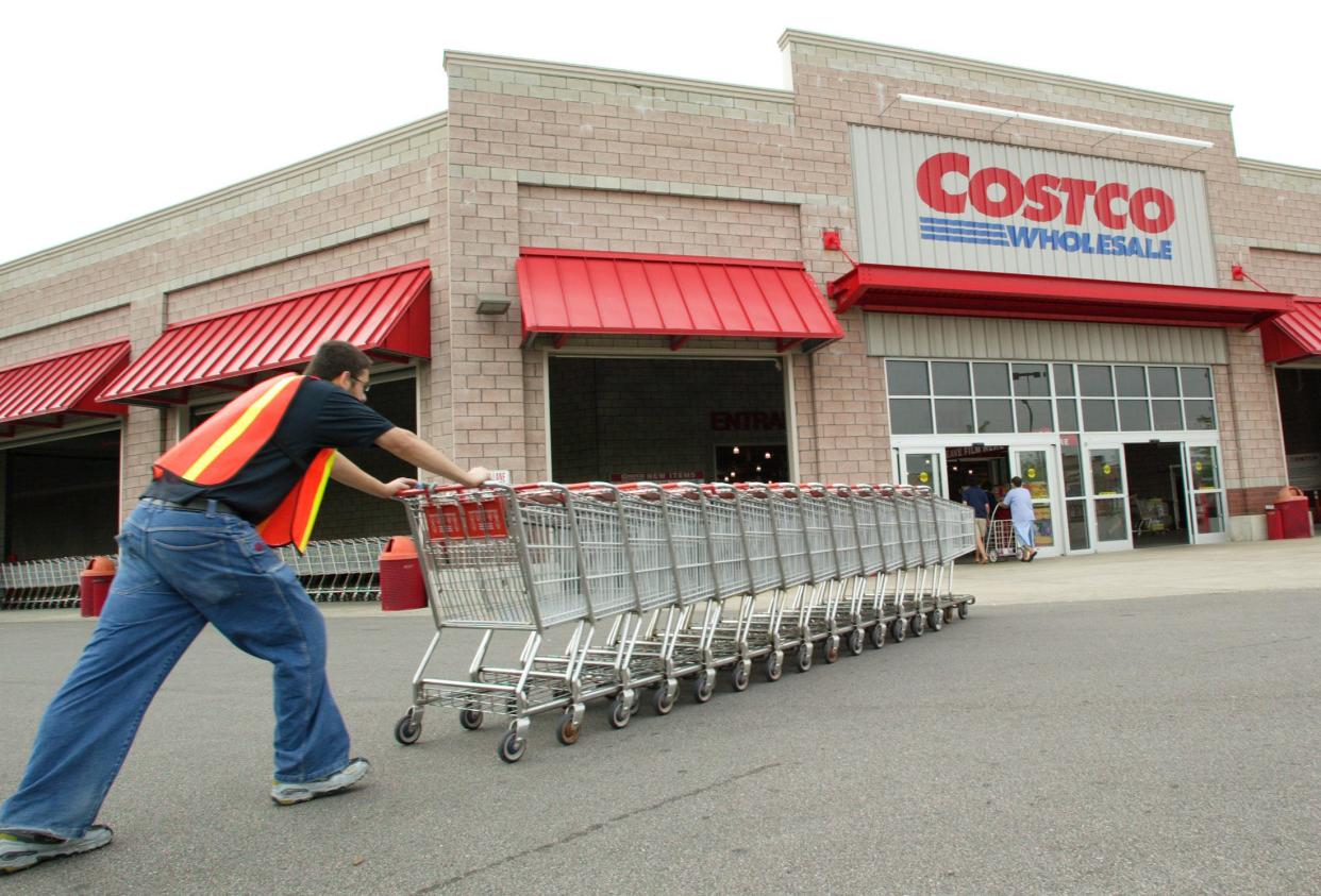 Costco worker pushes carts toward Costco warehouse